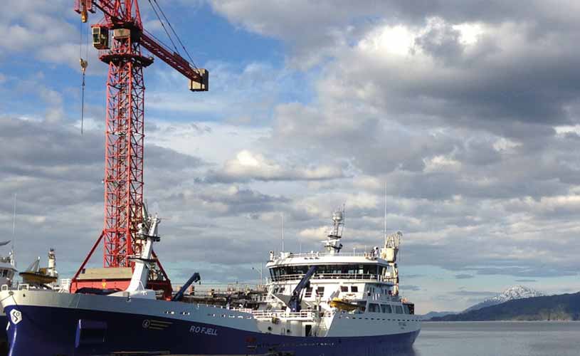 Ein Schiff angelegt am Steg, Kran im Hintergrund
