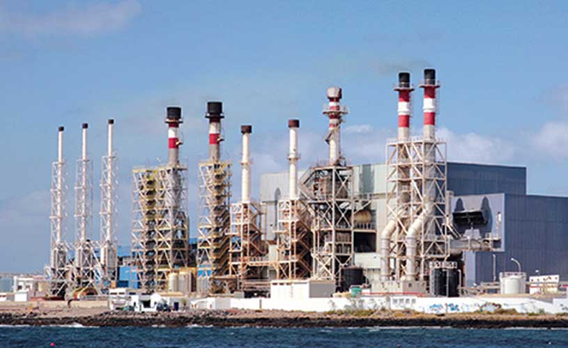 Industrieller Komplex mit Schornsteinen am Wasser