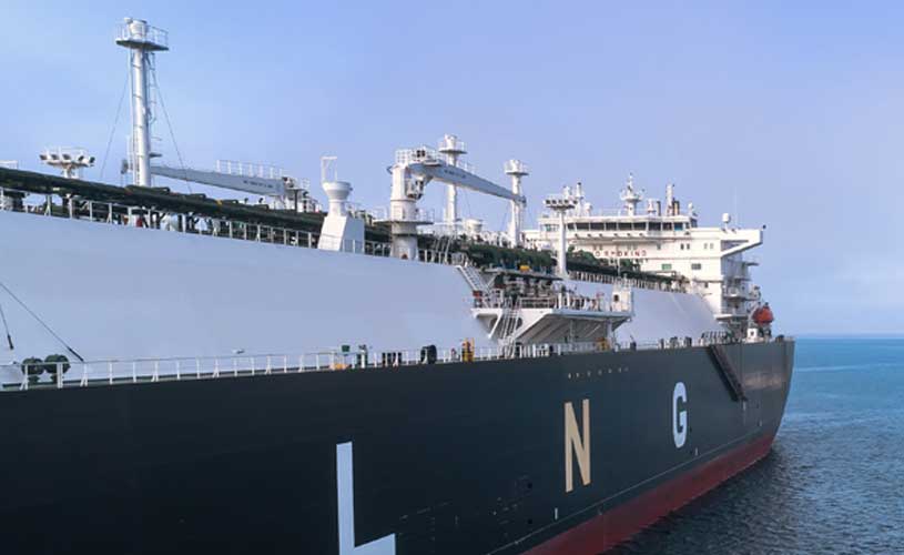 Grosses industrielles Schiff im Wasser, im Hintergrund huegelige Kueste