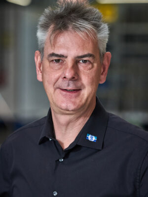 Mann in dunklem Hemd schaut freundlich in die Kamera