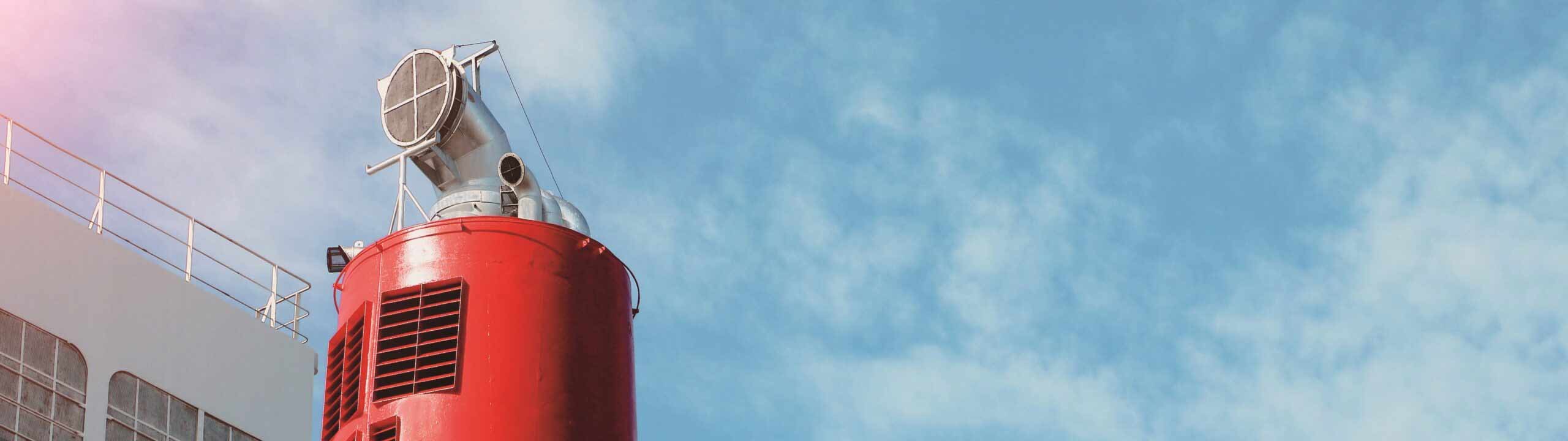 Abgasrohr mit Filter auf rotem Schiffsschornstein