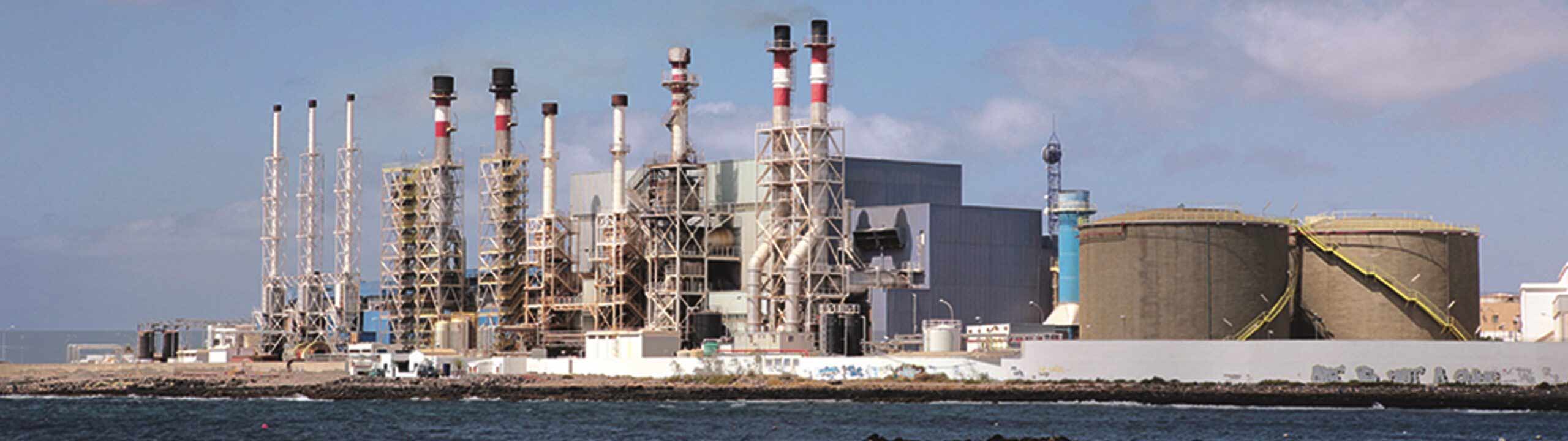 Industrieller Komplex mit Schornsteinen am Wasser