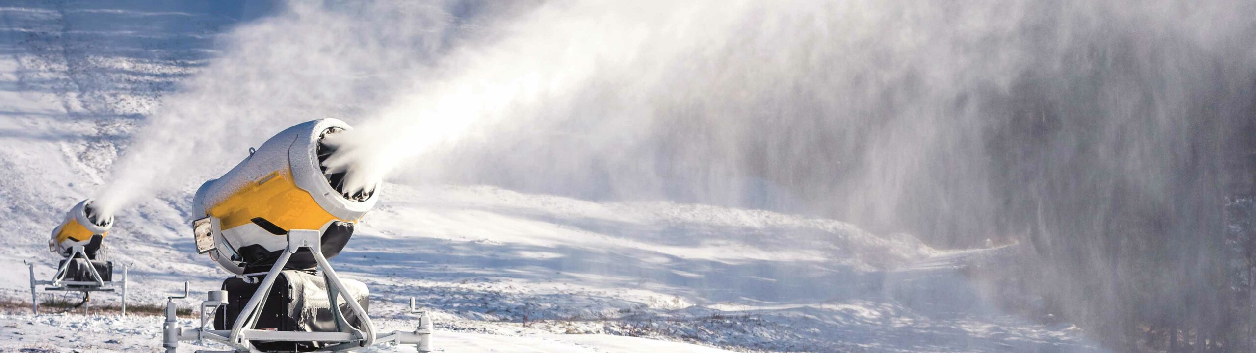 Schneekanone schiesst Schnee in verschneite Umgebung