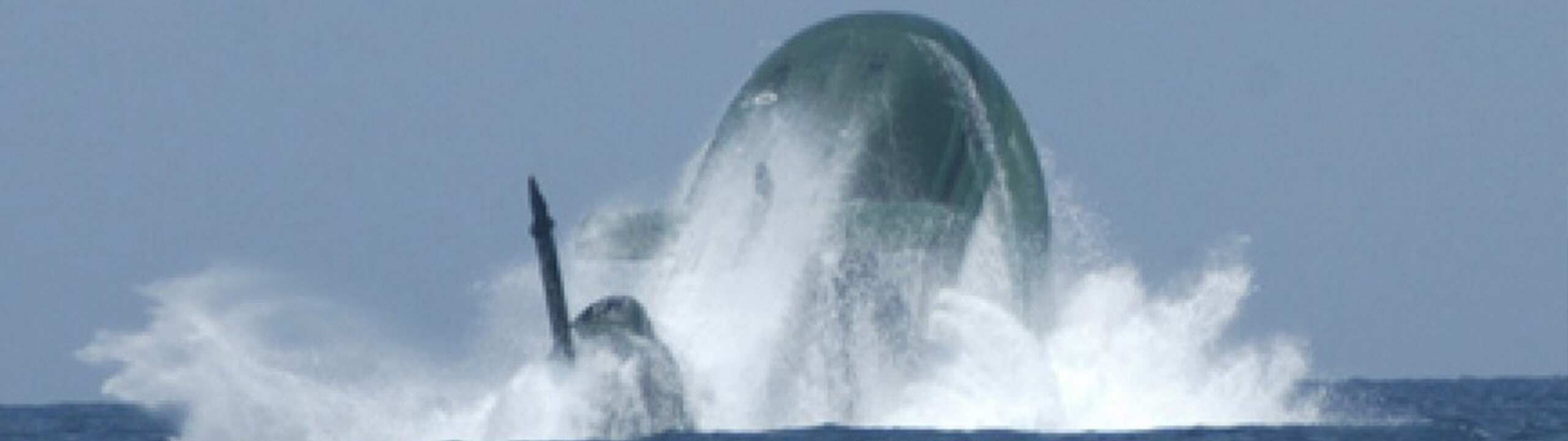 U-Boot taucht an Wasseroberflaeche auf, Wasser spritzt
